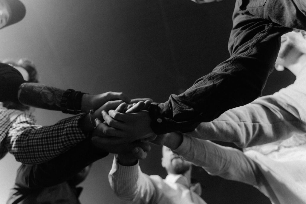 A group of diverse hands united in a gesture of teamwork and collaboration.